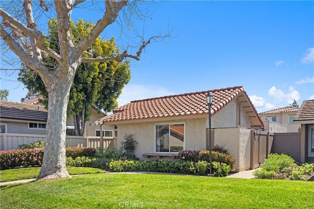 view of property exterior with a lawn, a tiled roof, stucco siding, and fence
