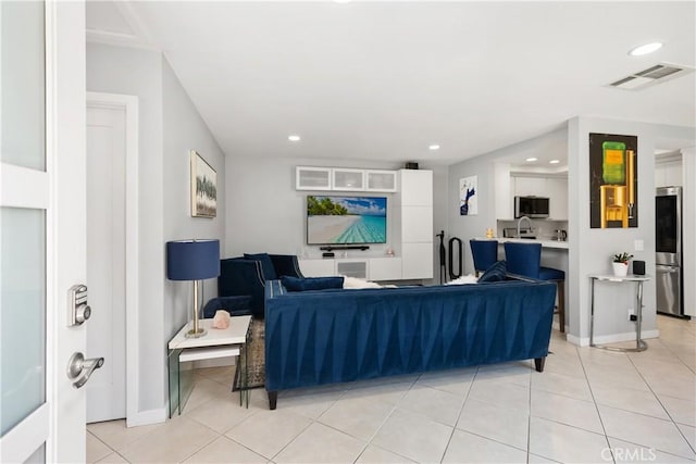 living area with recessed lighting, visible vents, baseboards, and light tile patterned floors