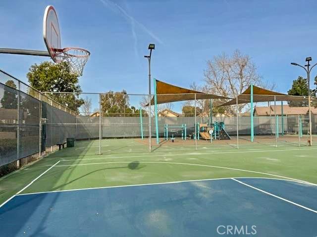 view of basketball court with community basketball court, fence, and playground community