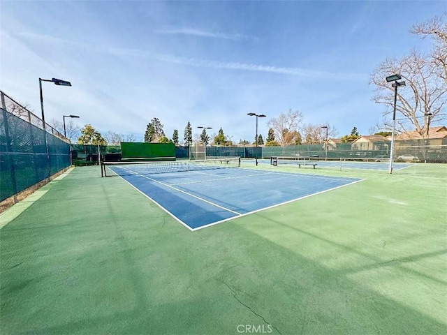 view of tennis court featuring fence