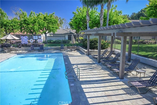 community pool with a pergola, a patio, and fence