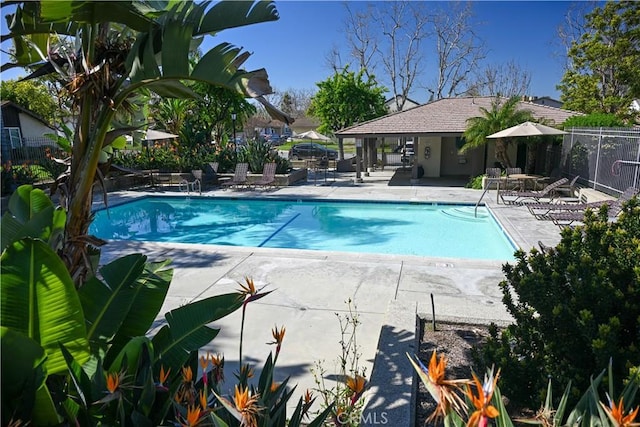 community pool with fence and a patio area