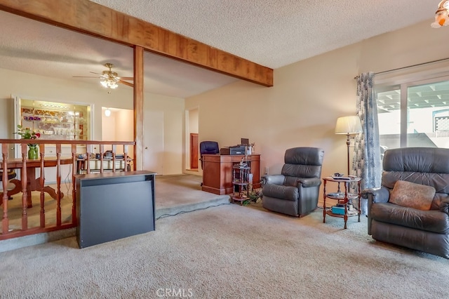 living area featuring beam ceiling, a ceiling fan, carpet, and a textured ceiling