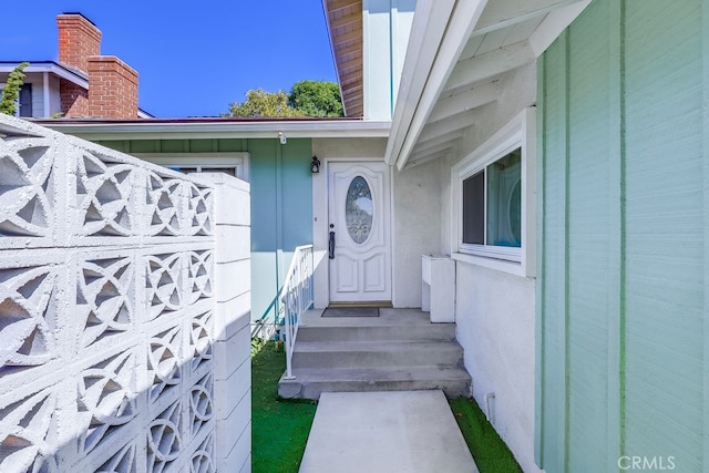 doorway to property featuring stucco siding