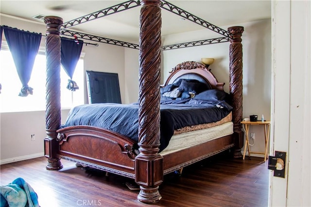 bedroom with baseboards and wood finished floors