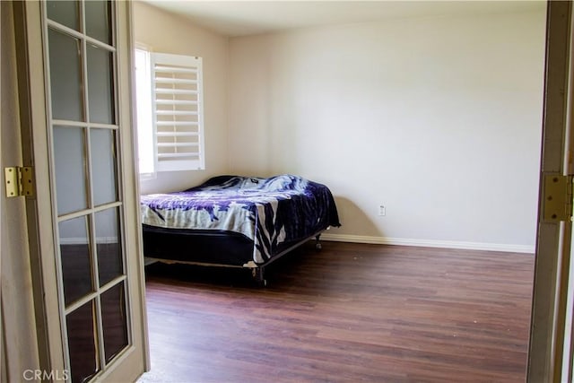 bedroom with baseboards and wood finished floors