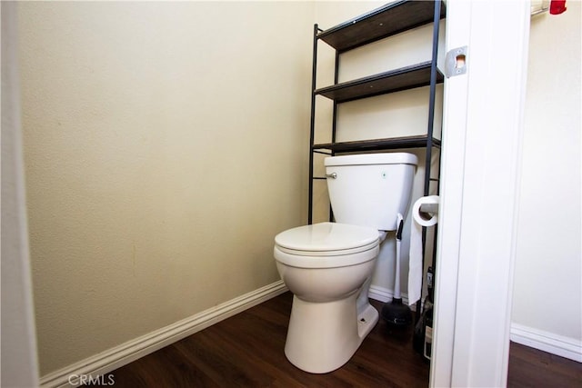 bathroom featuring toilet, baseboards, and wood finished floors