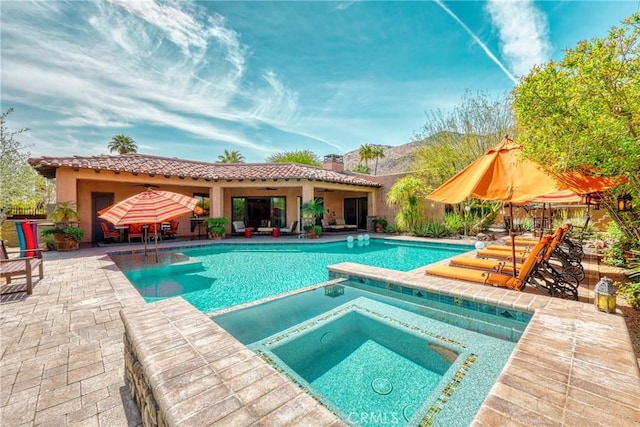 view of swimming pool with a patio area and a pool with connected hot tub