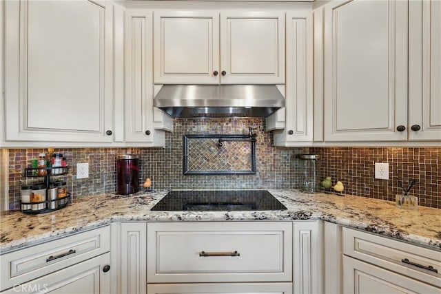 kitchen with white cabinets, black electric cooktop, backsplash, and exhaust hood