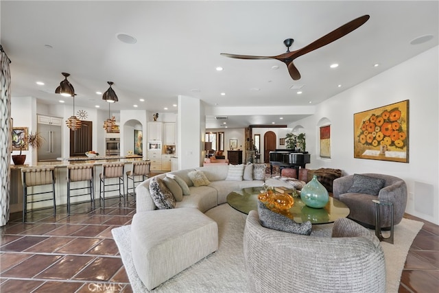 living room with arched walkways, ceiling fan, and recessed lighting