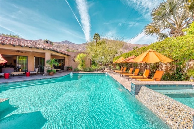 outdoor pool featuring a ceiling fan, an in ground hot tub, a mountain view, and a patio