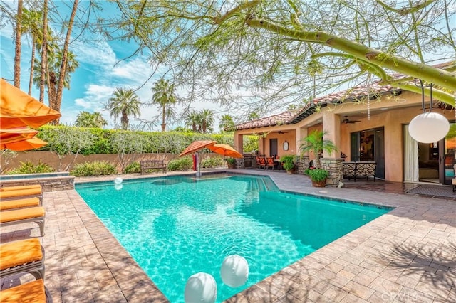 view of swimming pool featuring a fenced in pool, a fenced backyard, ceiling fan, a patio area, and an in ground hot tub