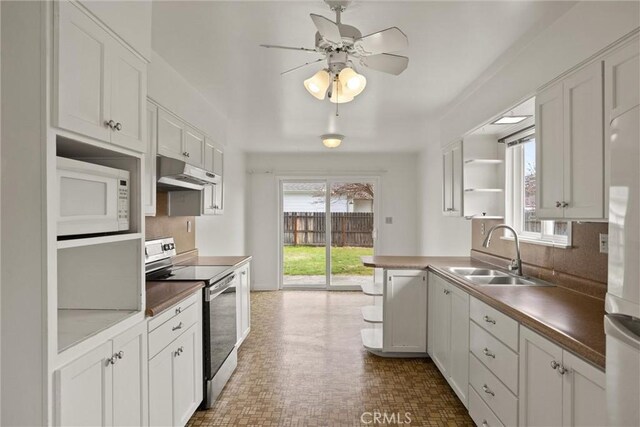 2909 Carlene Pl, Chico, CA 95973 - kitchen featuring stainless steel range with electric cooktop, a sink, white microwave, under cabinet range hood, and a ceiling fan