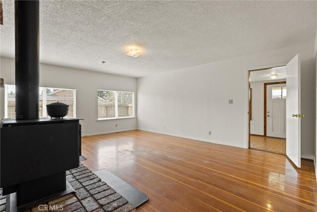 2909 Carlene Pl, Chico, CA 95973 - living area featuring a wood stove, wood finished floors, a textured ceiling, and baseboards