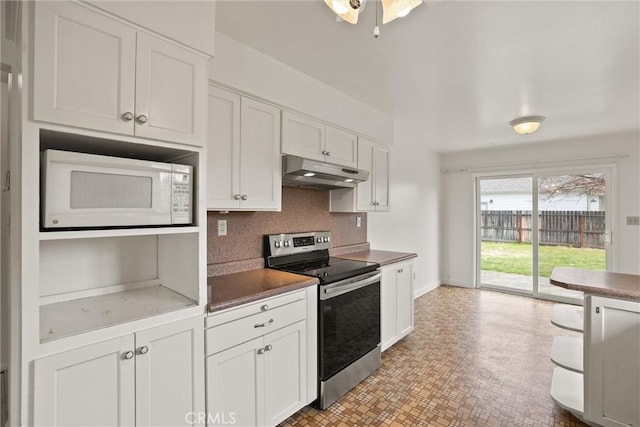 2909 Carlene Pl, Chico, CA 95973 - kitchen with stainless steel electric range, under cabinet range hood, white microwave, white cabinetry, and decorative backsplash