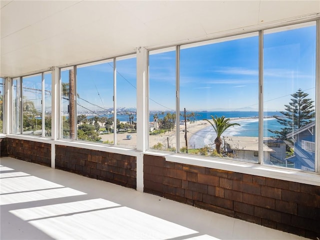 unfurnished sunroom featuring a water view