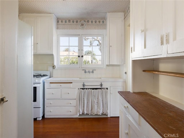 kitchen with gas range gas stove, white cabinets, dark wood-style floors, and a sink