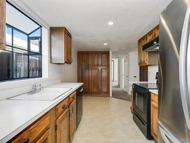 1714 Woodlark Ln, Fallbrook, CA 92028 - kitchen with black appliances, light countertops, a sink, brown cabinetry, and a textured ceiling