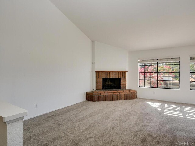 1714 Woodlark Ln, Fallbrook, CA 92028 - unfurnished living room featuring carpet flooring, a brick fireplace, and vaulted ceiling