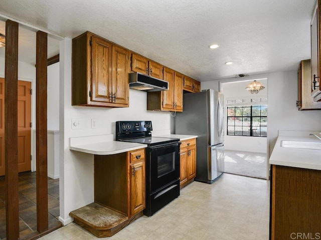 1714 Woodlark Ln, Fallbrook, CA 92028 - kitchen with black range with electric cooktop, under cabinet range hood, a sink, light countertops, and freestanding refrigerator