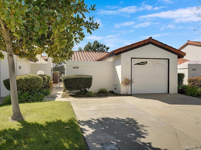 1714 Woodlark Ln, Fallbrook, CA 92028 - view of front facade featuring a tiled roof, stucco siding, a gate, concrete driveway, and a garage