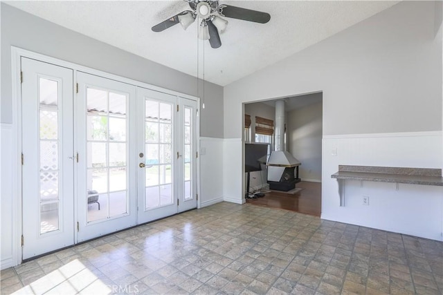 7320 Ramona Ave, Rancho Cucamonga, CA 91730 - entryway featuring a wood stove, french doors, vaulted ceiling, a ceiling fan, and wainscoting