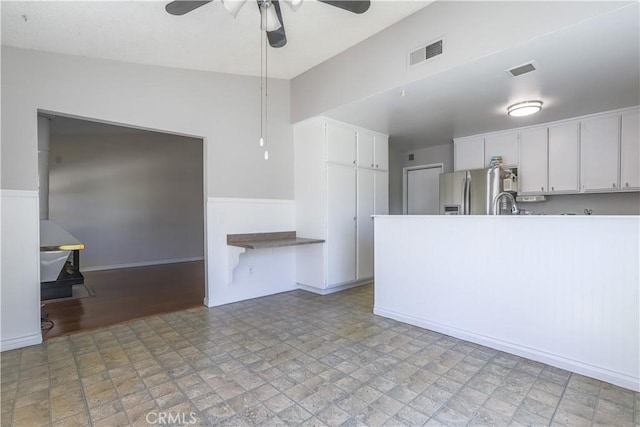 7320 Ramona Ave, Rancho Cucamonga, CA 91730 - kitchen with ceiling fan, white cabinets, stainless steel fridge, a peninsula, and light countertops