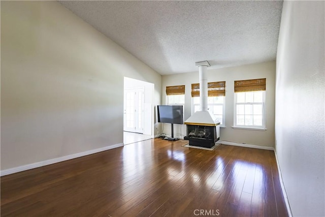 7320 Ramona Ave, Rancho Cucamonga, CA 91730 - unfurnished living room with a textured ceiling, baseboards, a wood stove, and wood finished floors