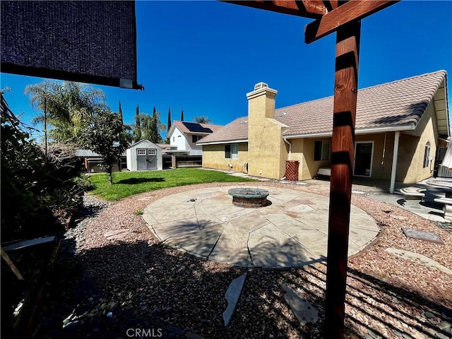 173 Victoria Ln, Calimesa, CA 92320 - rear view of house with a patio, a fire pit, a lawn, a chimney, and stucco siding