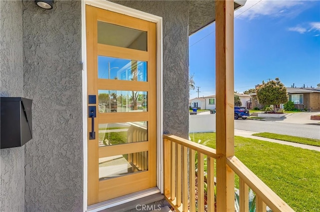 5039 W 135th St, Hawthorne, CA 90250 - property entrance with stucco siding, a lawn, and a porch