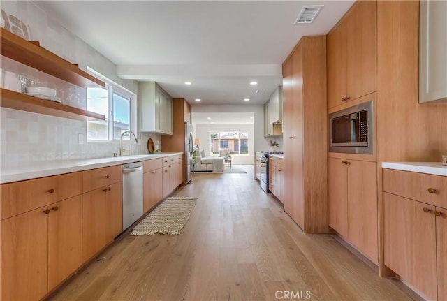 5039 W 135th St, Hawthorne, CA 90250 - kitchen featuring appliances with stainless steel finishes, light wood-style floors, light countertops, open shelves, and tasteful backsplash