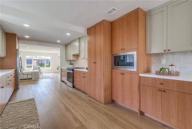 5039 W 135th St, Hawthorne, CA 90250 - kitchen with appliances with stainless steel finishes, light wood-style flooring, light countertops, tasteful backsplash, and recessed lighting