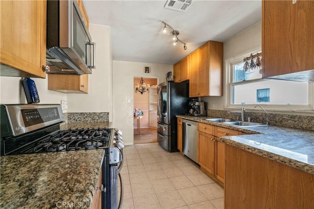 kitchen with visible vents, brown cabinetry, appliances with stainless steel finishes, light tile patterned flooring, and a sink