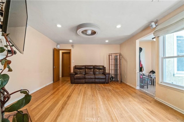 living room featuring recessed lighting, baseboards, and light wood-style floors