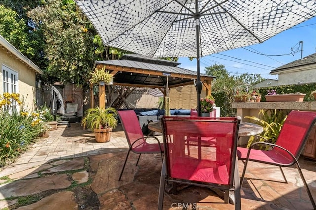 view of patio / terrace featuring a gazebo, outdoor dining space, and fence