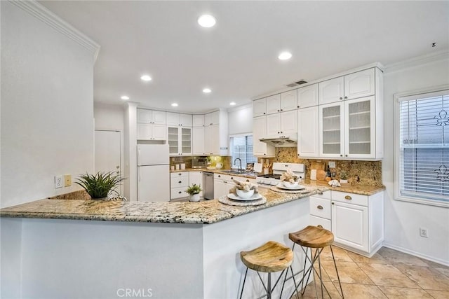 3184 Toopal Dr, Oceanside, CA 92058 - kitchen with white appliances, ornamental molding, under cabinet range hood, light stone counters, and tasteful backsplash