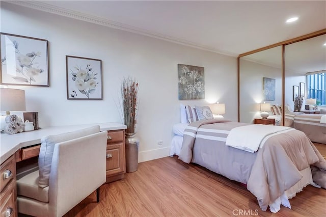 2999 E Ocean Blvd Unit 210, Long Beach, CA 90803 - bedroom with light wood-style floors, ornamental molding, a closet, baseboards, and a desk