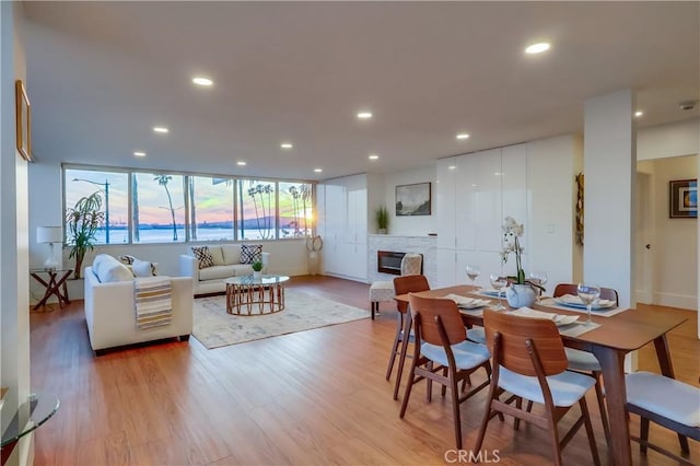 2999 E Ocean Blvd Unit 210, Long Beach, CA 90803 - dining area featuring a glass covered fireplace, light wood-style floors, recessed lighting, and baseboards