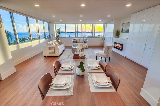2999 E Ocean Blvd Unit 210, Long Beach, CA 90803 - dining space featuring baseboards, light wood-style floors, recessed lighting, and a glass covered fireplace