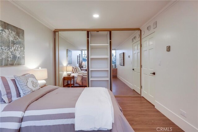 2999 E Ocean Blvd Unit 210, Long Beach, CA 90803 - bedroom featuring crown molding, wood finished floors, a closet, recessed lighting, and baseboards