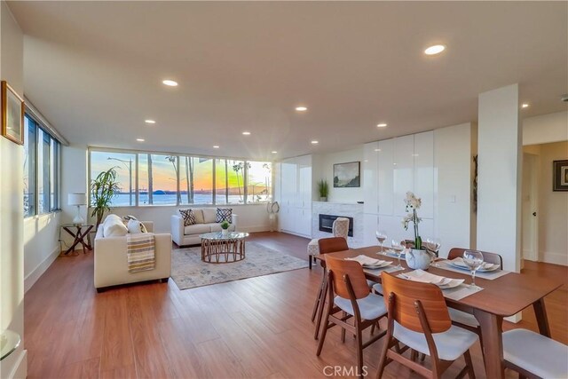 2999 E Ocean Blvd Unit 210, Long Beach, CA 90803 - dining area featuring plenty of natural light, a fireplace, recessed lighting, light wood-type flooring, and baseboards