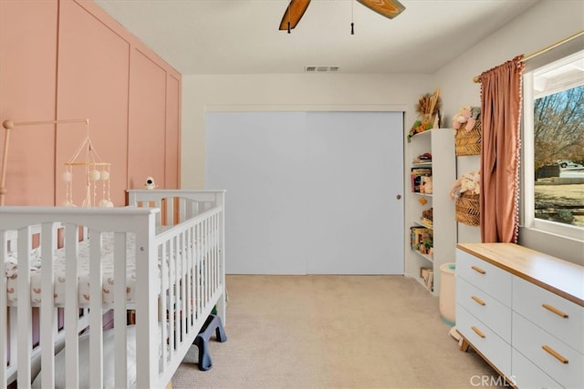 57716 Juarez Dr, Yucca Valley, CA 92284 - bedroom featuring light carpet, a crib, a closet, and a ceiling fan