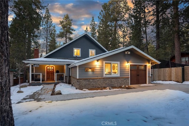 41496 Comstock Ln, Big Bear Lake, CA 92315 - view of front of property with fence, covered porch, stone siding, and a chimney