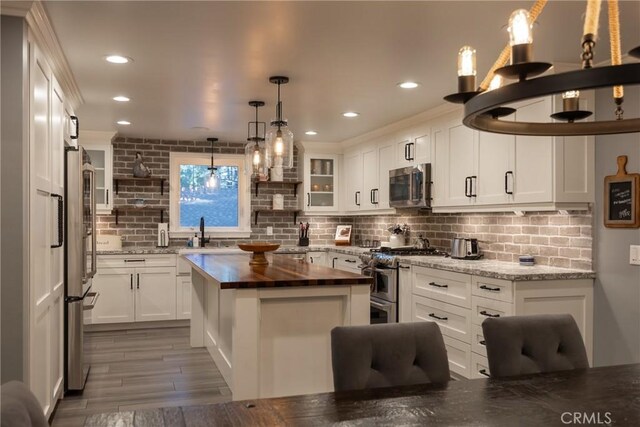 41496 Comstock Ln, Big Bear Lake, CA 92315 - kitchen with open shelves, butcher block counters, decorative backsplash, appliances with stainless steel finishes, and a sink
