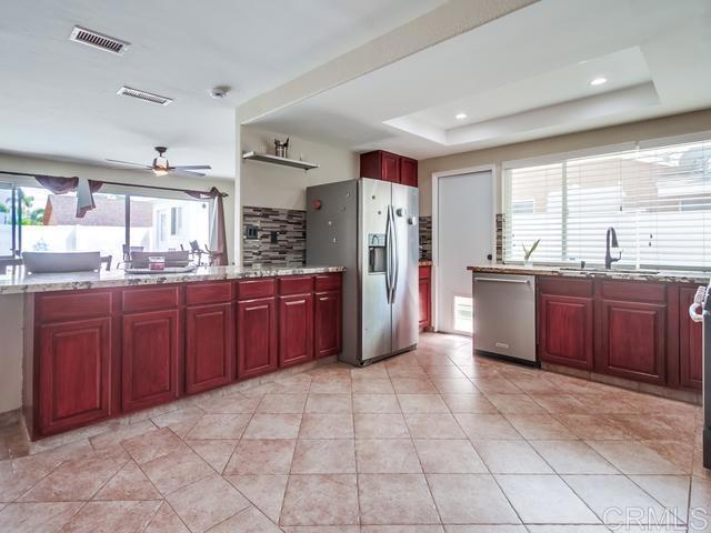kitchen with stainless steel appliances, a ceiling fan, a sink, and dark brown cabinets