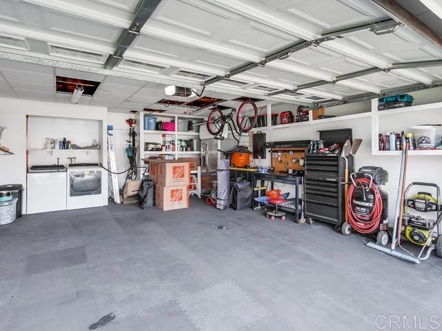garage featuring washer and dryer, a workshop area, and a garage door opener