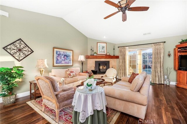 18051 Bold Venture Dr, Tehachapi, CA 93561 - living room featuring visible vents, a fireplace with raised hearth, ceiling fan, vaulted ceiling, and dark wood-style floors