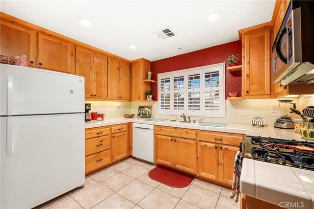 18051 Bold Venture Dr, Tehachapi, CA 93561 - kitchen with white appliances, tile countertops, visible vents, open shelves, and tasteful backsplash