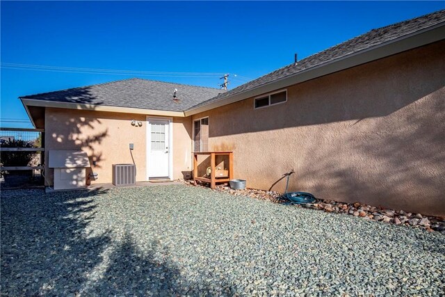 18051 Bold Venture Dr, Tehachapi, CA 93561 - back of property featuring a shingled roof, central AC, and stucco siding