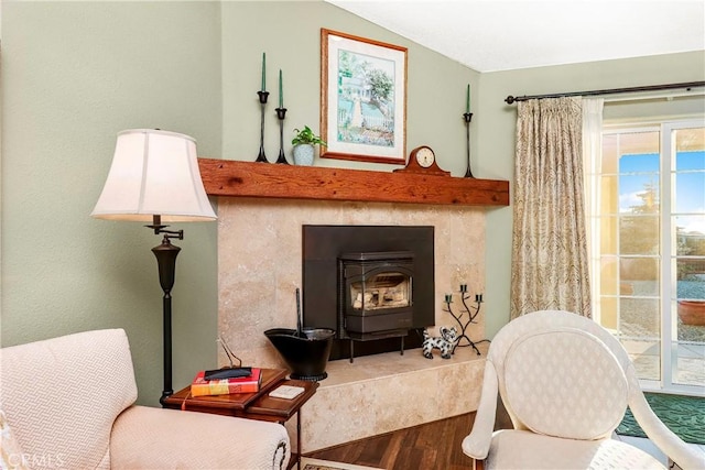 18051 Bold Venture Dr, Tehachapi, CA 93561 - sitting room with vaulted ceiling, a healthy amount of sunlight, a wood stove, and wood finished floors
